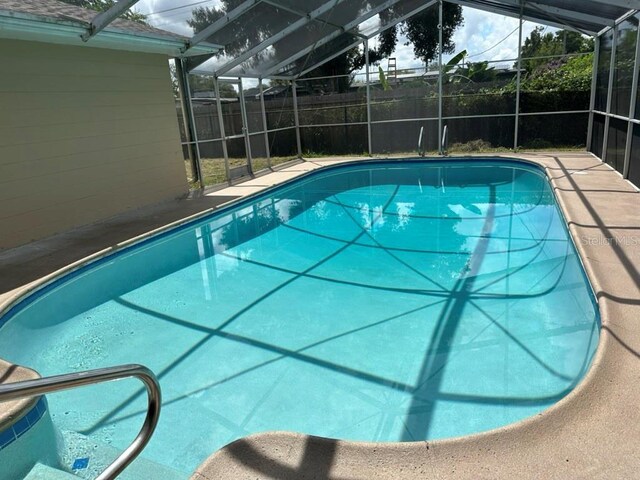 view of swimming pool featuring a lanai