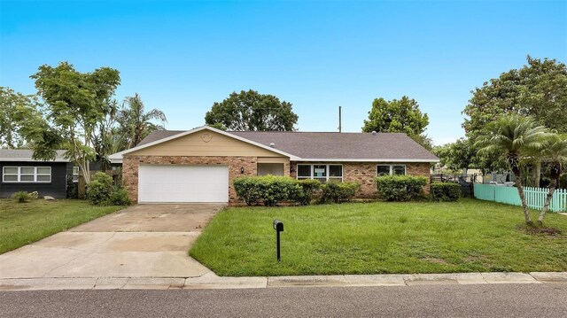 ranch-style house with a front yard, an attached garage, and concrete driveway