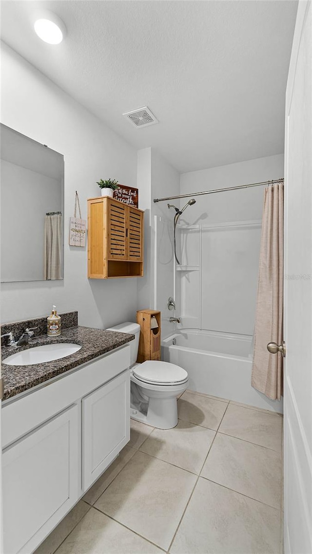 full bathroom with vanity, toilet, shower / bath combo, a textured ceiling, and tile patterned flooring