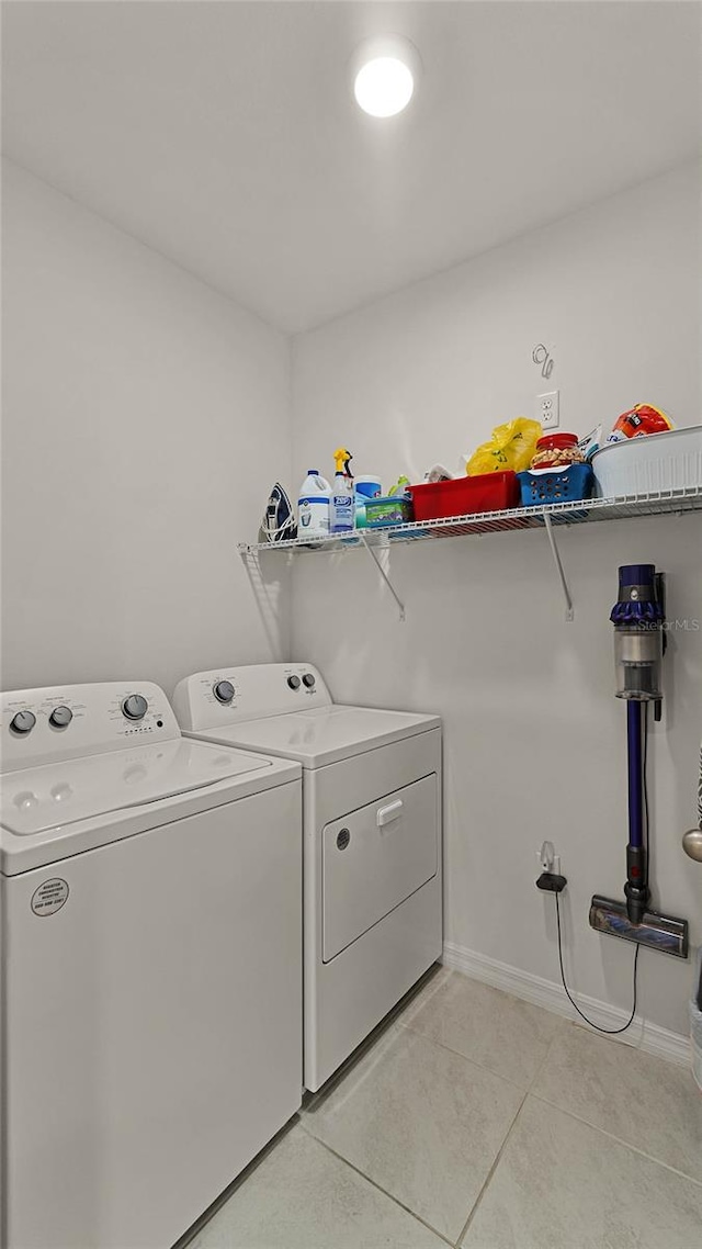 laundry room featuring independent washer and dryer and light tile patterned flooring