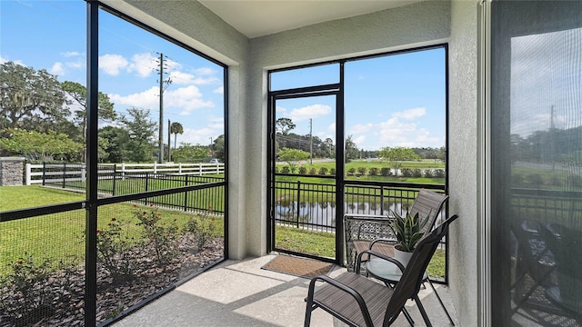 sunroom featuring a water view