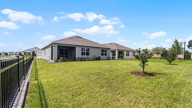 back of property featuring a lawn, a sunroom, and central air condition unit