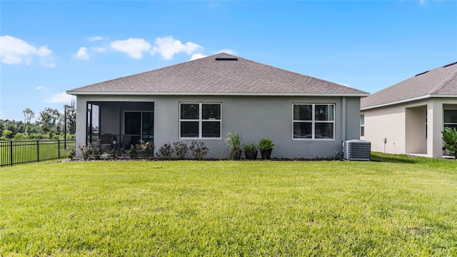 rear view of house with a lawn and central AC