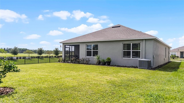 back of house featuring a yard and central AC unit