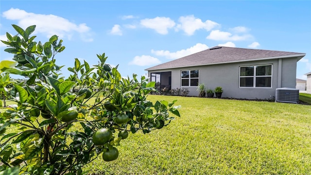 back of property featuring a yard and central AC