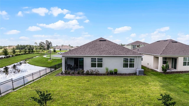 back of property featuring cooling unit and a yard