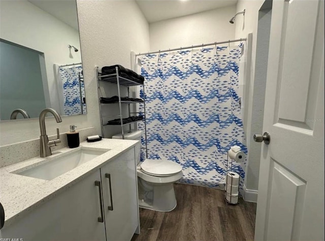 bathroom featuring curtained shower, wood-type flooring, toilet, and vanity