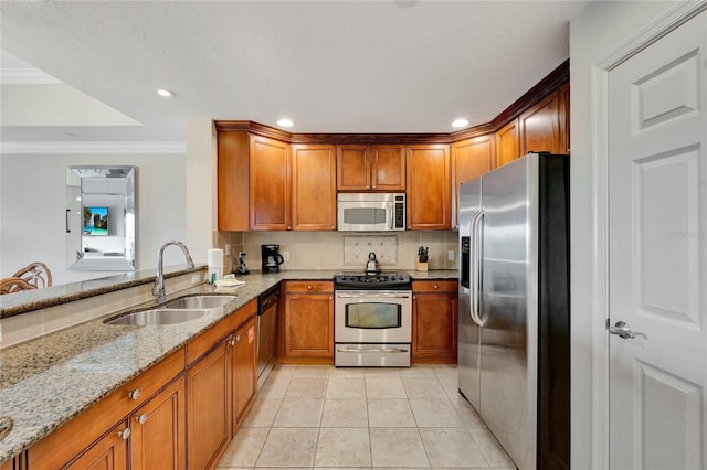 kitchen with appliances with stainless steel finishes, tasteful backsplash, light stone countertops, ornamental molding, and sink