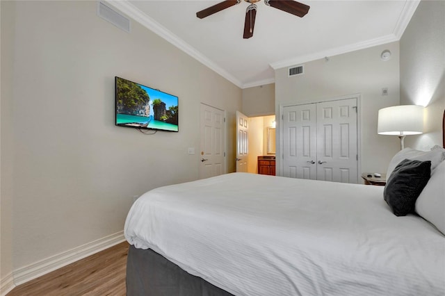 bedroom featuring ceiling fan, a closet, ornamental molding, and wood-type flooring