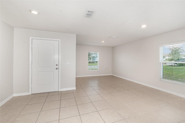 tiled spare room with a healthy amount of sunlight