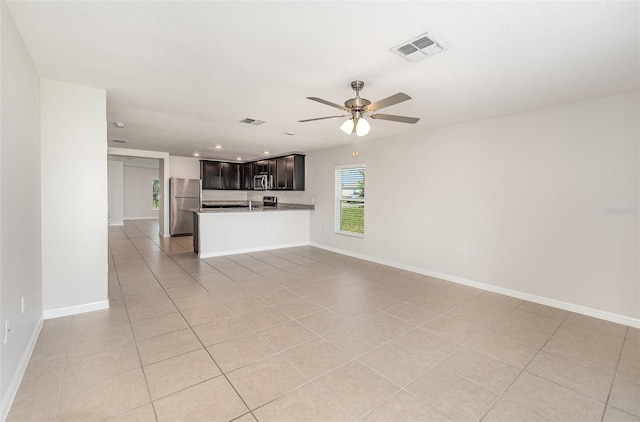 unfurnished living room with ceiling fan and light tile patterned floors