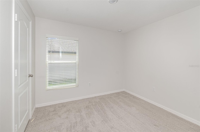 spare room featuring a healthy amount of sunlight and light carpet