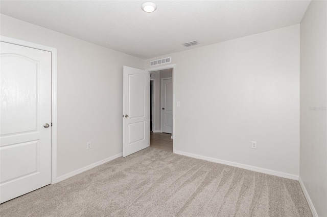 unfurnished room featuring light carpet