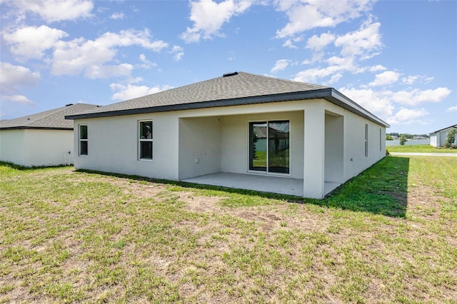 rear view of house featuring a patio and a yard