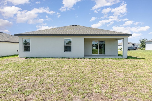 rear view of property featuring a lawn