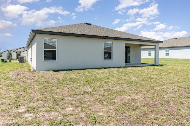 rear view of house featuring a lawn, cooling unit, and a patio