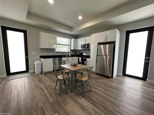 kitchen with white cabinets, stainless steel appliances, and dark hardwood / wood-style floors