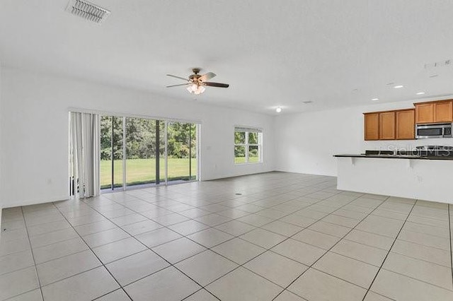 unfurnished living room with ceiling fan and light tile patterned floors