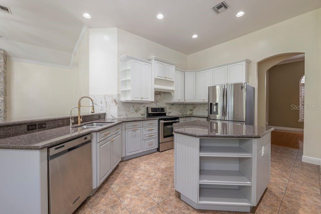 kitchen with tasteful backsplash, sink, stainless steel appliances, and white cabinets