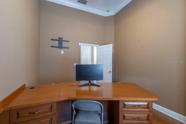 home office with hardwood / wood-style flooring, built in desk, and ornamental molding