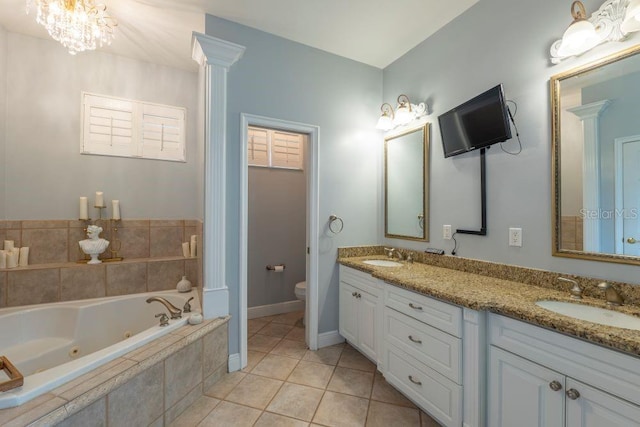 bathroom featuring tile patterned flooring, vanity, toilet, and a relaxing tiled tub