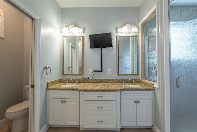 bathroom featuring vanity, tile patterned flooring, a shower with shower door, and toilet