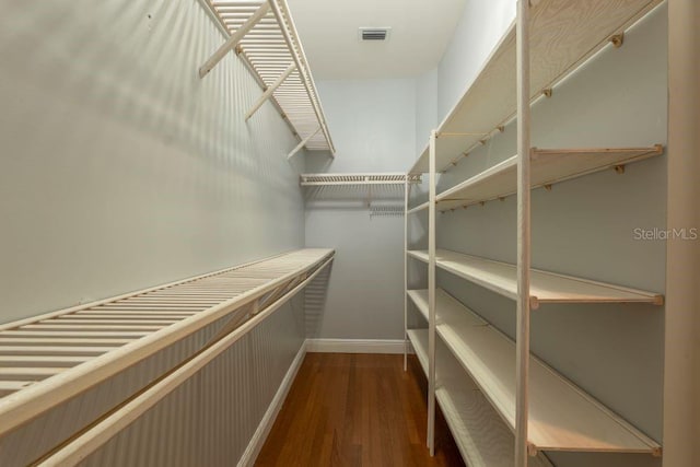 spacious closet featuring dark hardwood / wood-style floors