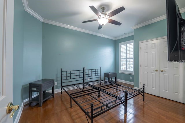 bedroom featuring wood-type flooring, a closet, ceiling fan, and crown molding