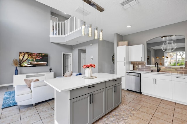 kitchen with dishwasher, sink, gray cabinetry, backsplash, and decorative light fixtures