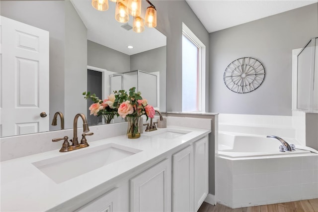 bathroom featuring an inviting chandelier, shower with separate bathtub, hardwood / wood-style floors, and vanity