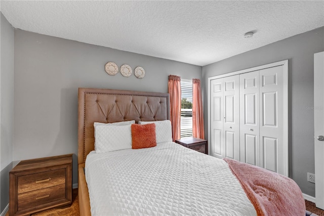 bedroom with a textured ceiling, carpet flooring, and a closet