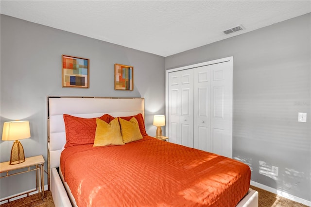 bedroom featuring a textured ceiling, a closet, and carpet flooring