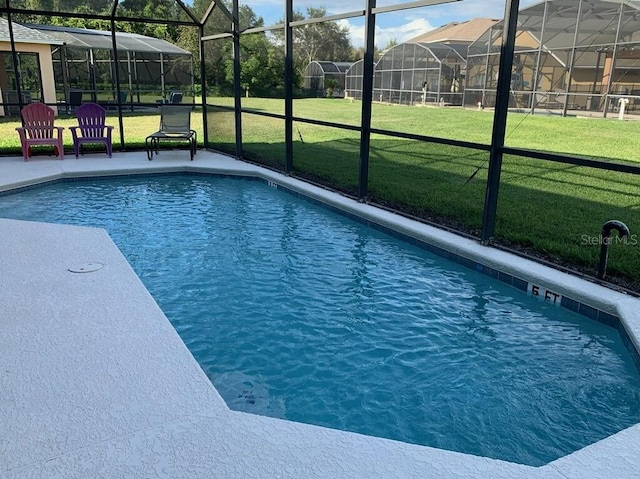 view of swimming pool featuring glass enclosure and a yard