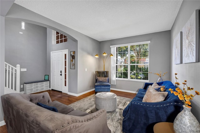 living room with a textured ceiling and dark hardwood / wood-style floors