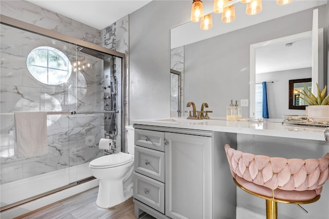 bathroom with walk in shower, wood-type flooring, vanity, and toilet