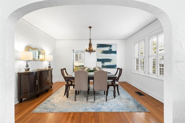 dining room featuring hardwood / wood-style floors and a chandelier