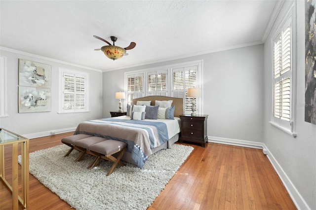 bedroom with ceiling fan, ornamental molding, and light wood-type flooring