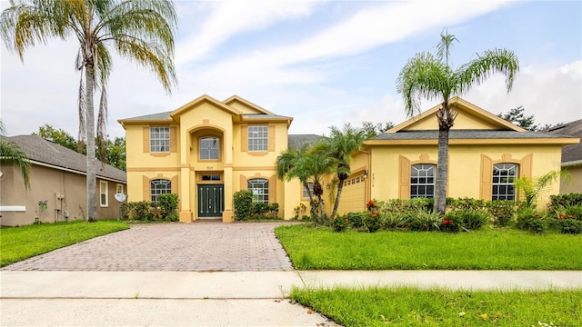 mediterranean / spanish house featuring a front yard and a garage