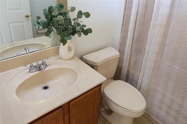 bathroom with tile patterned flooring, vanity, and toilet