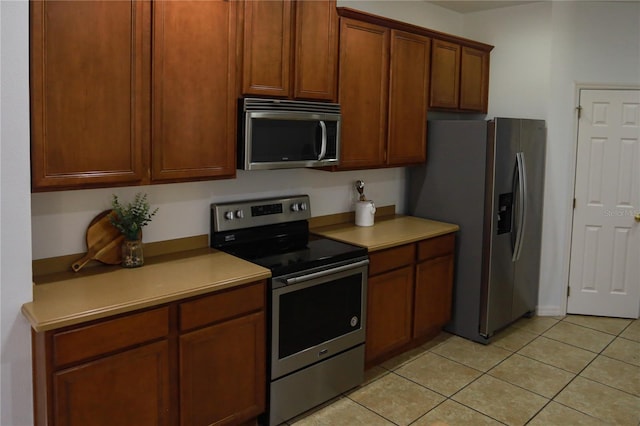 kitchen with light tile patterned floors and stainless steel appliances