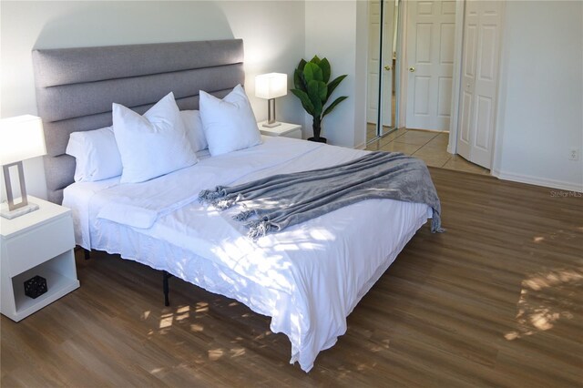 bedroom with dark hardwood / wood-style floors and a closet