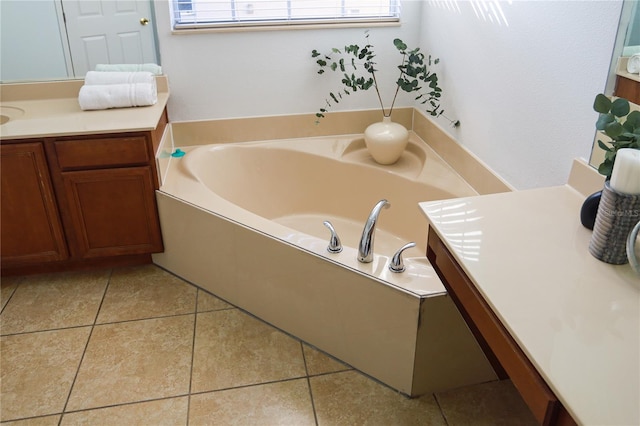 bathroom with tile patterned floors, a washtub, and vanity