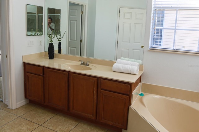 bathroom with tile patterned flooring, a bathtub, and vanity