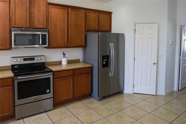 kitchen with light tile patterned floors and appliances with stainless steel finishes