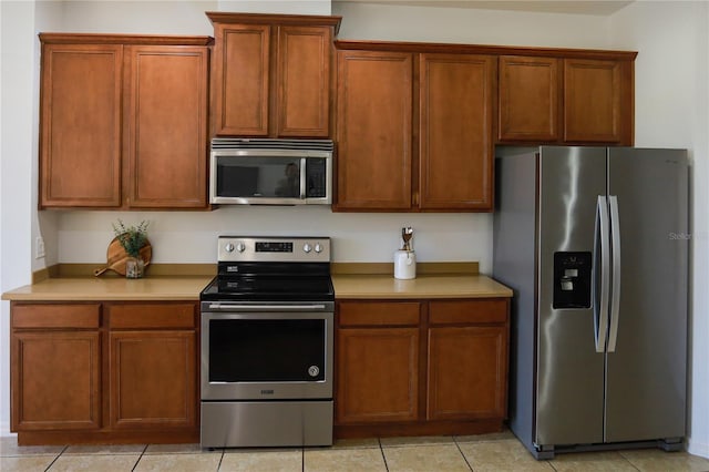 kitchen with appliances with stainless steel finishes and light tile patterned floors