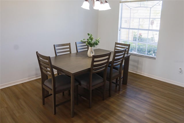 dining area featuring dark hardwood / wood-style floors and an inviting chandelier