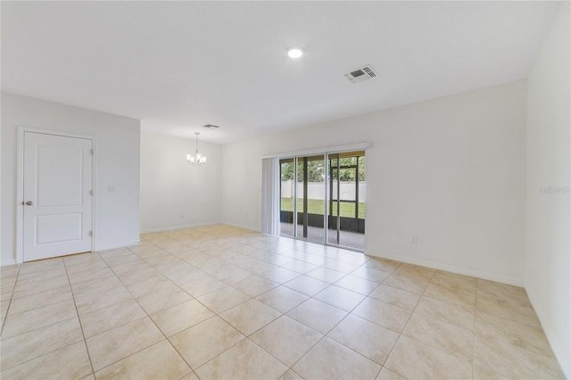 unfurnished room featuring an inviting chandelier and light tile patterned floors