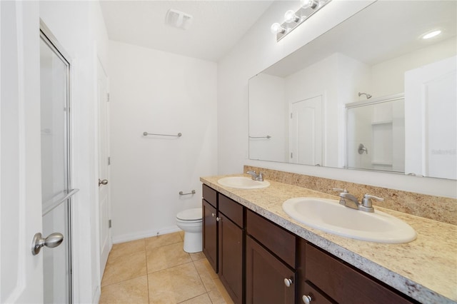 bathroom featuring tile patterned floors, a shower with door, vanity, and toilet