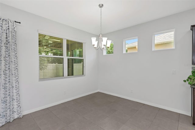 tiled empty room with a notable chandelier