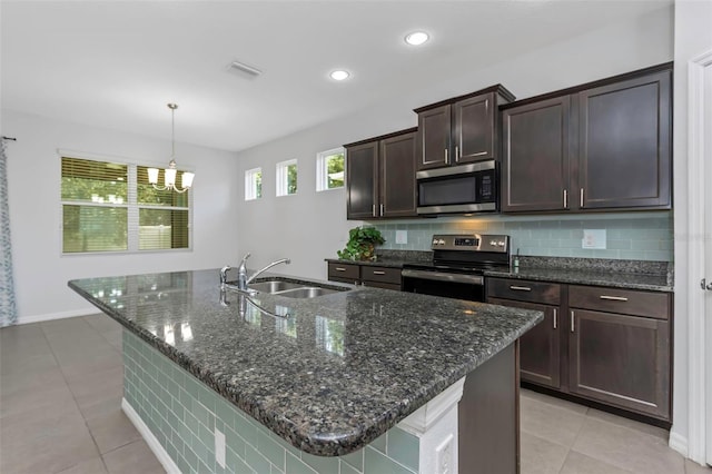 kitchen with pendant lighting, a center island with sink, sink, appliances with stainless steel finishes, and dark brown cabinets